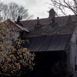 Roofing crew stripping old roofing shingles to be recycled.