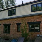After photo showing new black windows and everlast composite siding.