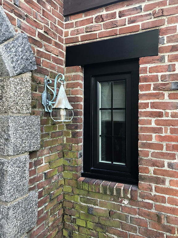 Beautiful new black casement window installed in brick.