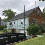 Inprogress photo showing green guard backer board before the installation of new vinyl siding.