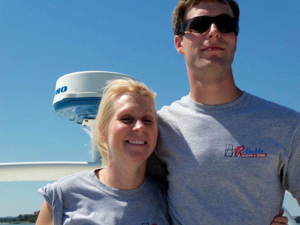 Rob and Carol pictured wearing Reliable Roofing, Siding , and Window T-shirts on Albie's boat.
