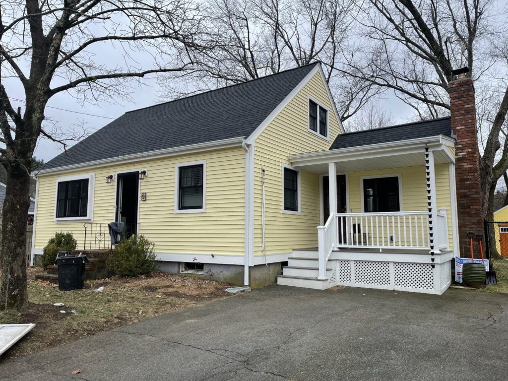 after photo showing front elevation new roofing, siding, windows, doors, and porch