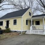 after photo showing front elevation new roofing, siding, windows, doors, and porch