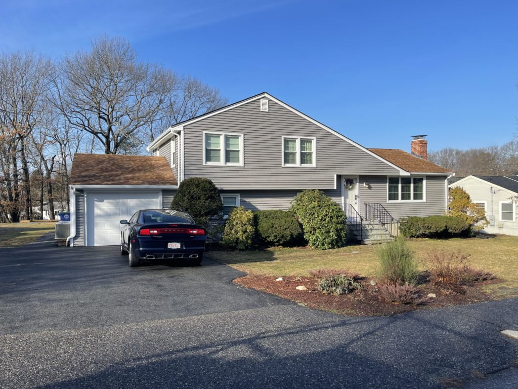 After Photo showing Entry Door, Garage Door, and vinyl siding installed