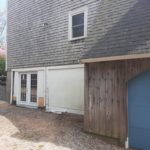 before photo of right elevation of home showing old wood shingle siding.