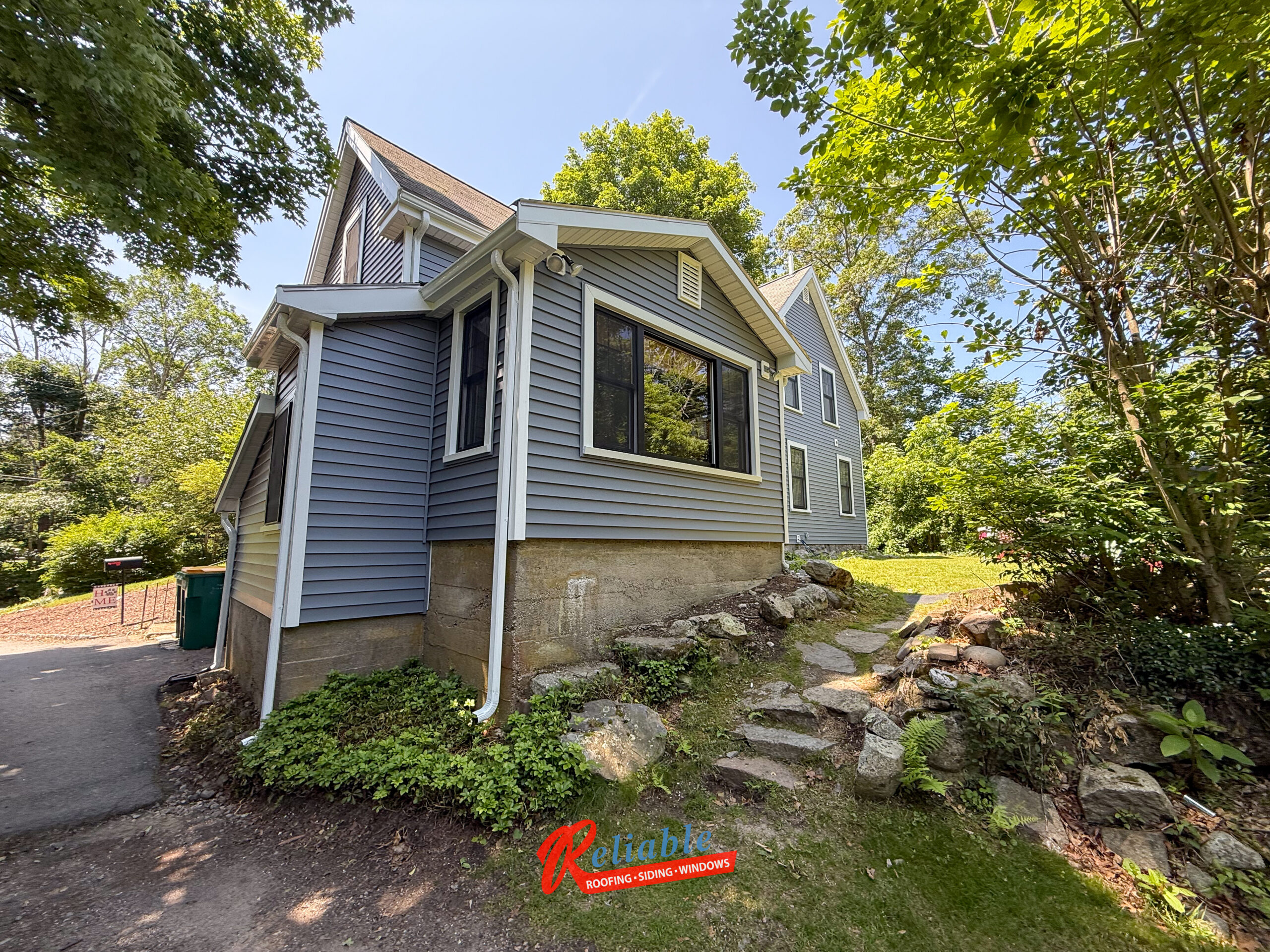 Before exterior renovation in Easton MA with outdated siding and windows