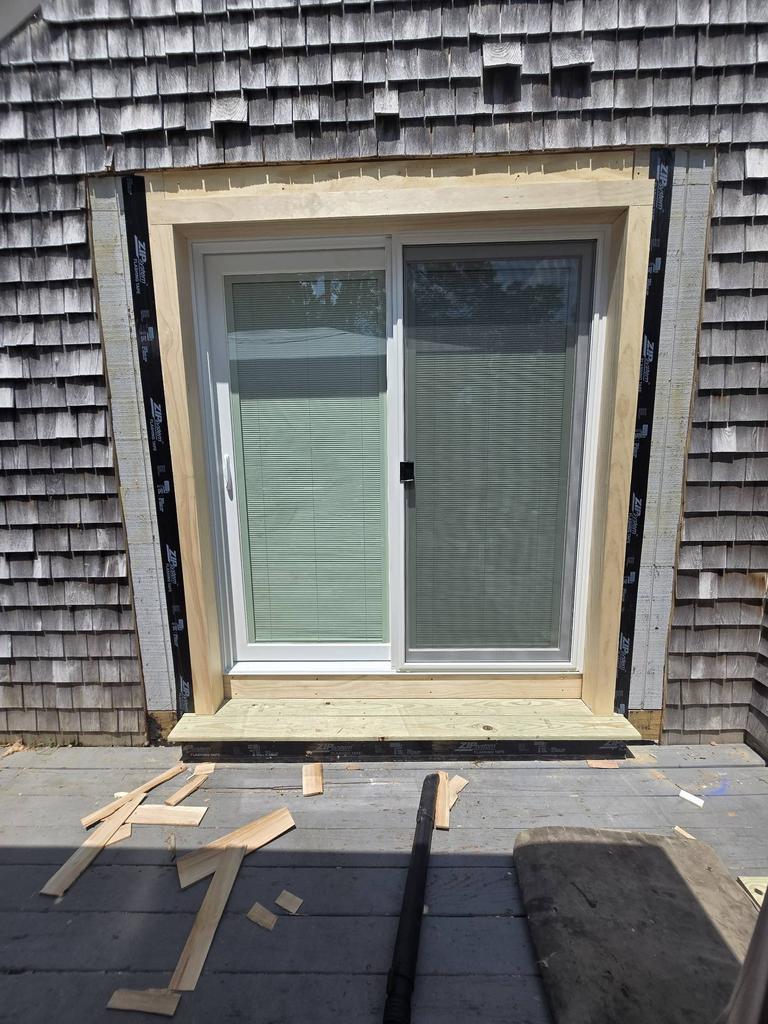 Harvey Classic white vinyl patio door with blinds between the glass installed in Randolph MA exterior renovation, providing natural light, privacy, and low maintenance